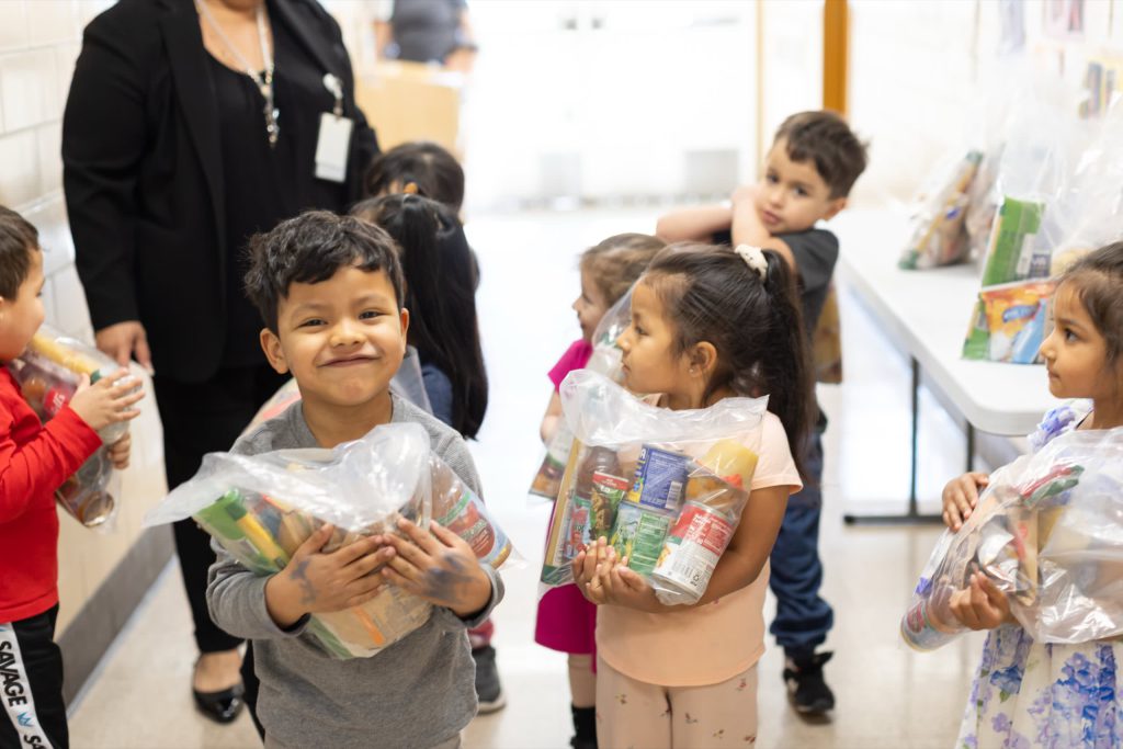 Kids happily clutching bags of food